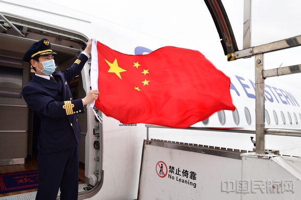 东航机组挥舞国旗，迎接我国首批援外抗疫专家组从浦东机场登机启程前往意大利（本文图片由东航提供）